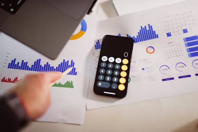 Business analytics setup with calculator, graphs, and laptop, showcasing financial insights. Analytics careers: facts, examples and trends